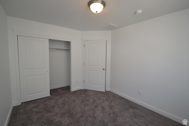 unfurnished bedroom with a closet, carpet flooring, and baseboards