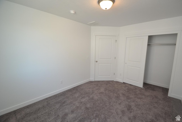 unfurnished bedroom with a closet, baseboards, and carpet