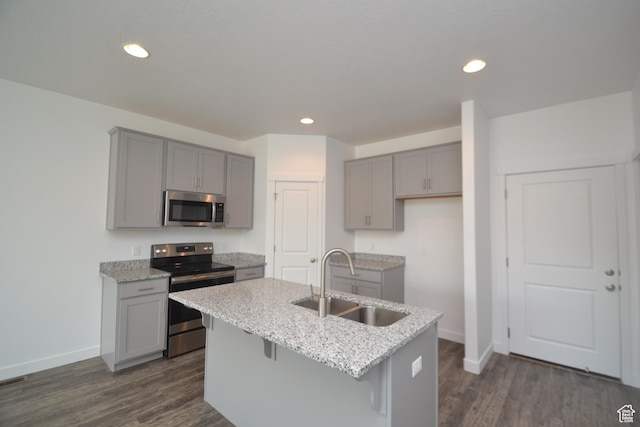 kitchen with gray cabinets, appliances with stainless steel finishes, a sink, and baseboards