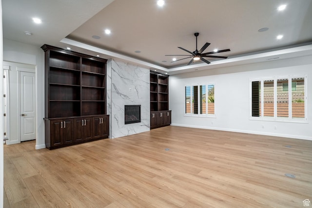 2889 E 1400 S, St George, UT 84790 - unfurnished living room featuring a raised ceiling, light wood-style floors, a ceiling fan, and built in shelves