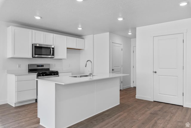 1748 S Windy Ridge Dr Unit 1281, Spanish Fork, UT 84660 - kitchen with white cabinets, a sink, appliances with stainless steel finishes, wood finished floors, and a center island with sink