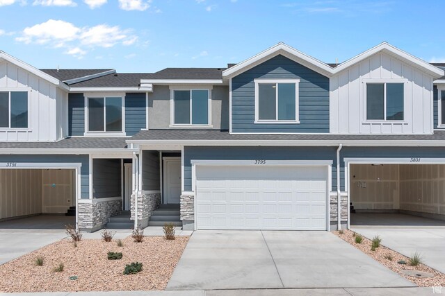 1748 S Windy Ridge Dr Unit 1281, Spanish Fork, UT 84660 - view of front of home with driveway, board and batten siding, stone siding, and an attached garage