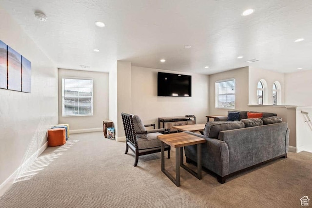 living area with baseboards, recessed lighting, and light carpet