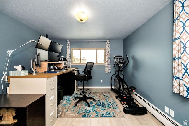 home office featuring baseboards, a baseboard heating unit, wood finished floors, and a textured ceiling