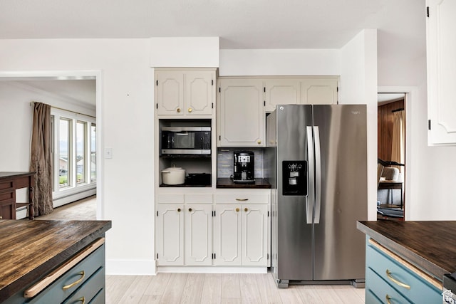 kitchen with light wood-style floors, blue cabinetry, appliances with stainless steel finishes, a baseboard radiator, and wood counters