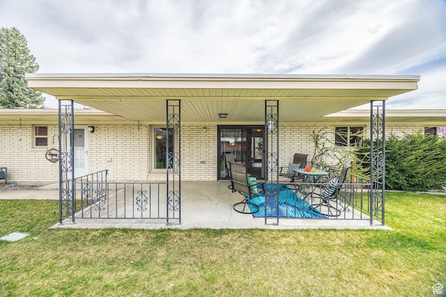 back of property with brick siding, a lawn, and covered porch