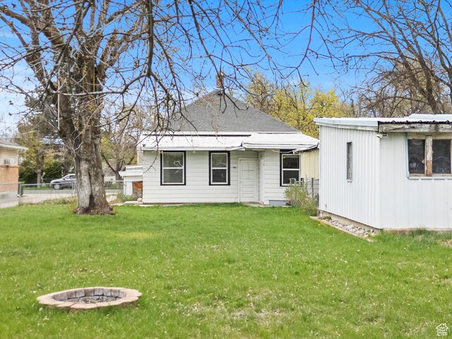 180 S 300 E, Logan, UT 84321 - rear view of house with fence, a fire pit, and a lawn
