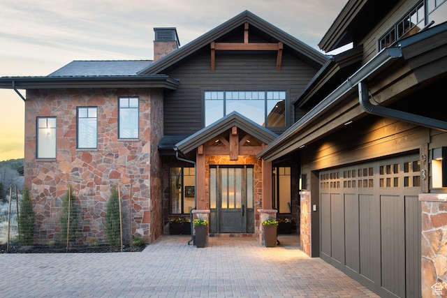 craftsman inspired home featuring a chimney and stone siding