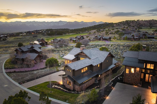 aerial view at dusk featuring a mountain view and a residential view