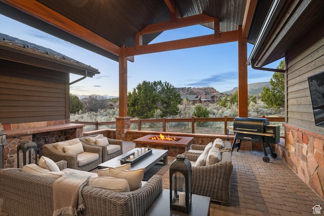 view of patio featuring an outdoor living space with a fire pit, a mountain view, and a grill