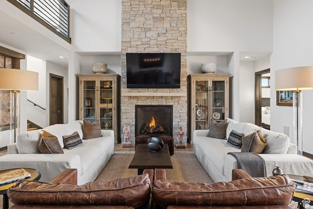 living area featuring a fireplace, stairway, and a towering ceiling