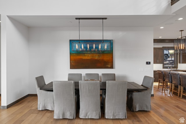 dining room featuring wood finished floors, baseboards, and recessed lighting