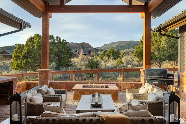 view of patio featuring an outdoor living space with a fire pit, a mountain view, and grilling area