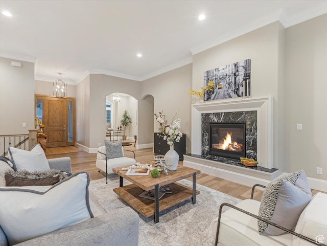 2219 E Fair Winns Ln, Draper, UT 84020 - living room featuring crown molding, light wood-style flooring, arched walkways, recessed lighting, and a chandelier