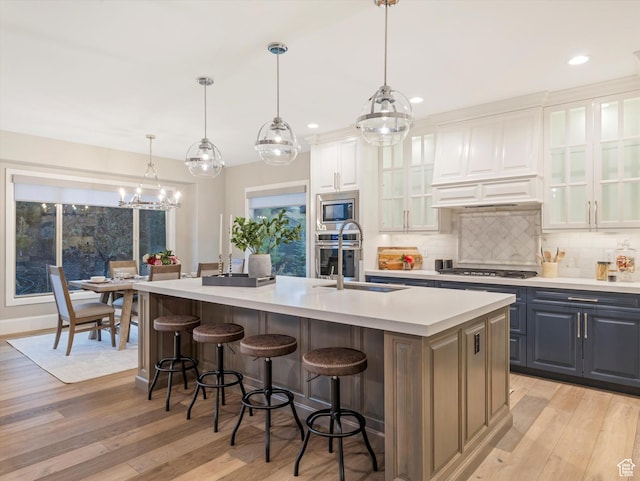 2219 E Fair Winns Ln, Draper, UT 84020 - kitchen featuring tasteful backsplash, appliances with stainless steel finishes, a sink, light countertops, and a center island with sink