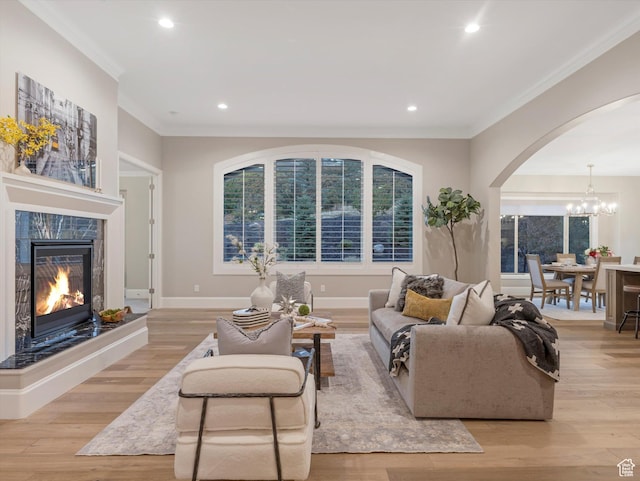 2219 E Fair Winns Ln, Draper, UT 84020 - living area featuring a tiled fireplace, ornamental molding, arched walkways, and a notable chandelier