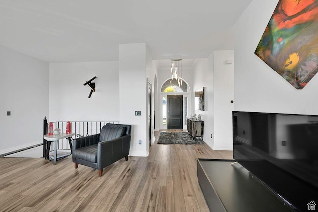sitting room featuring light wood-style flooring, baseboards, and baseboard heating