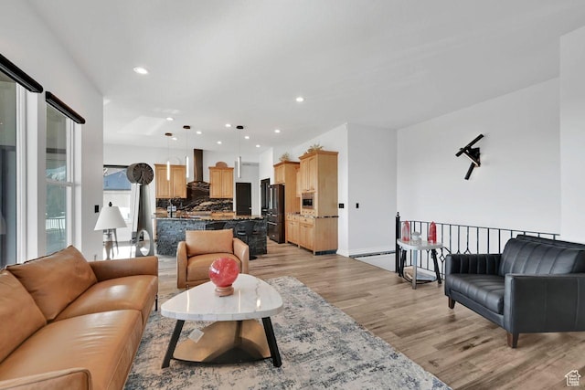 living area with recessed lighting, light wood-type flooring, and baseboards