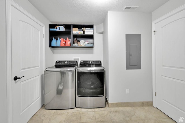 laundry area featuring electric panel, a textured ceiling, visible vents, laundry area, and washing machine and clothes dryer