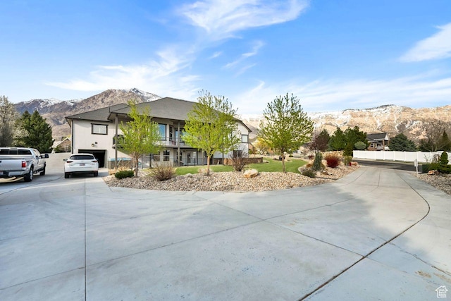 view of front facade featuring a mountain view, stucco siding, and driveway