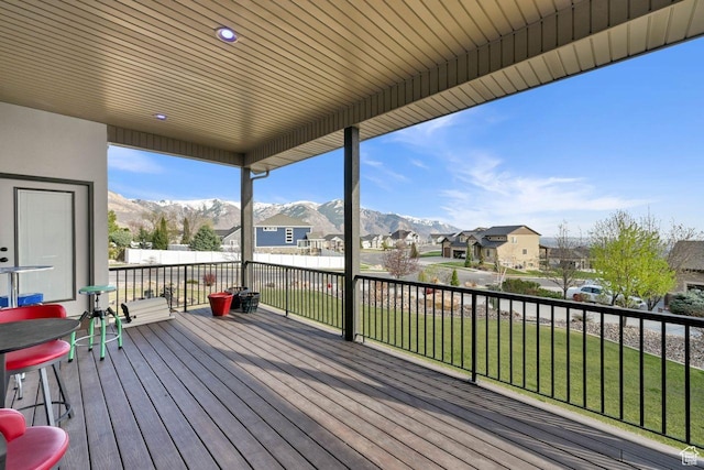 deck featuring a yard, a mountain view, and a residential view