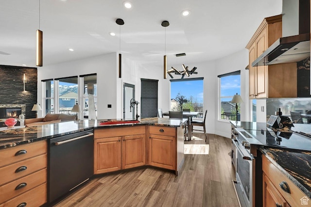 kitchen featuring wall chimney range hood, open floor plan, electric range, dishwashing machine, and wood finished floors