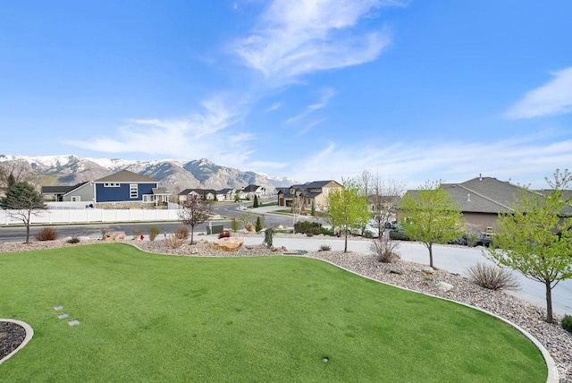 view of yard with a residential view, fence, and a mountain view