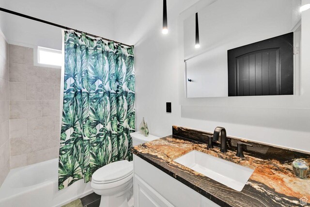 bathroom with shower / tub combo with curtain, vanity, and toilet