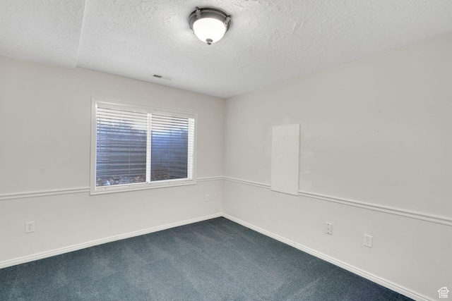 8046 W Harker Canyon Dr, Magna, UT 84044 - spare room with a textured ceiling, visible vents, dark carpet, and baseboards