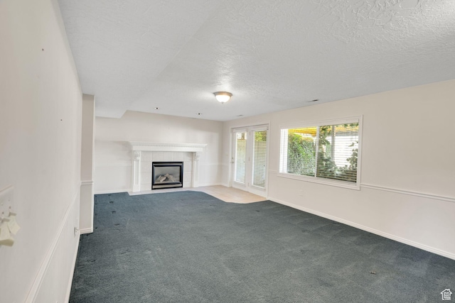 8046 W Harker Canyon Dr, Magna, UT 84044 - unfurnished living room with a tile fireplace, a textured ceiling, carpet, and baseboards
