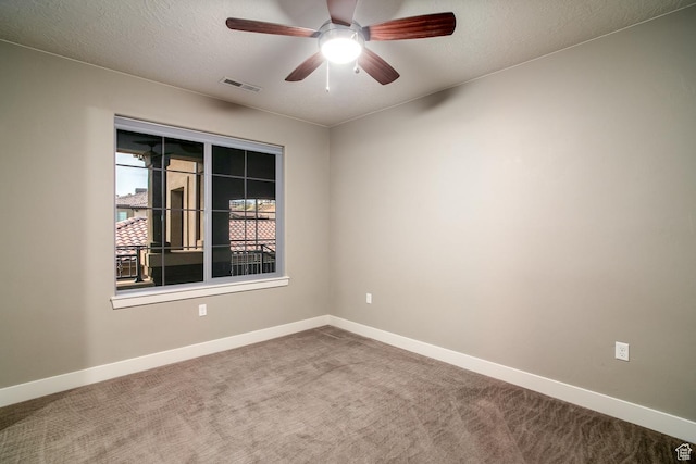carpeted empty room with visible vents, baseboards, ceiling fan, and a textured ceiling
