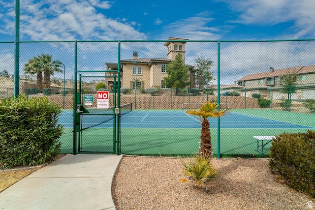 view of tennis court with fence and a gate