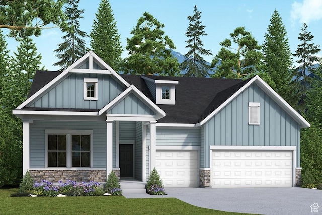 view of front of property with an attached garage, board and batten siding, driveway, and stone siding