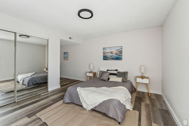 1039 E Quail Vista Ln Unit I, Salt Lake City, UT 84117 - bedroom with visible vents, baseboards, a closet, and wood finished floors