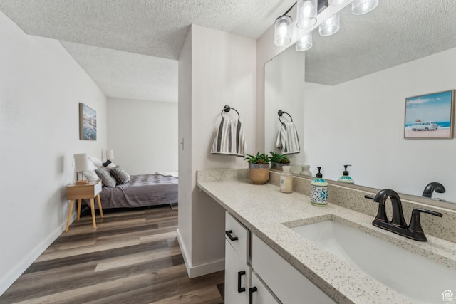 1039 E Quail Vista Ln Unit I, Salt Lake City, UT 84117 - ensuite bathroom featuring baseboards, a textured ceiling, connected bathroom, vanity, and wood finished floors