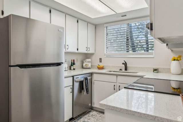 1039 E Quail Vista Ln Unit I, Salt Lake City, UT 84117 - kitchen with light stone counters, white cabinetry, visible vents, appliances with stainless steel finishes, and a sink
