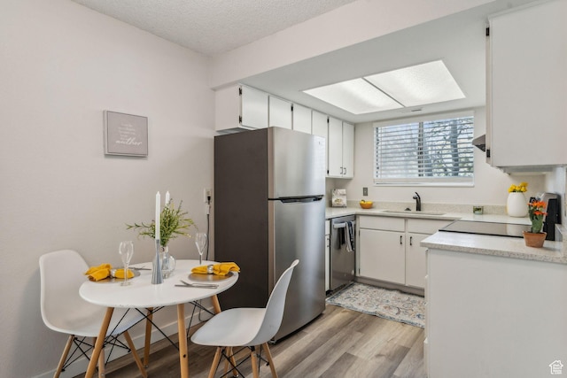 1039 E Quail Vista Ln Unit I, Salt Lake City, UT 84117 - kitchen with a sink, light countertops, appliances with stainless steel finishes, and light wood-style floors