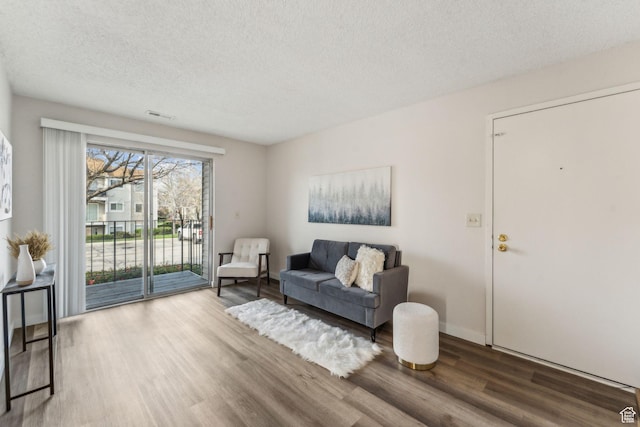 1039 E Quail Vista Ln Unit I, Salt Lake City, UT 84117 - living area featuring a textured ceiling, wood finished floors, and visible vents