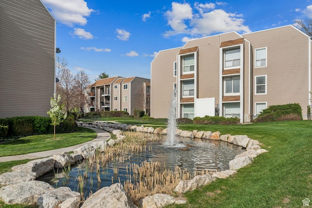 1039 E Quail Vista Ln Unit I, Salt Lake City, UT 84117 - view of property's community featuring a small pond and a lawn