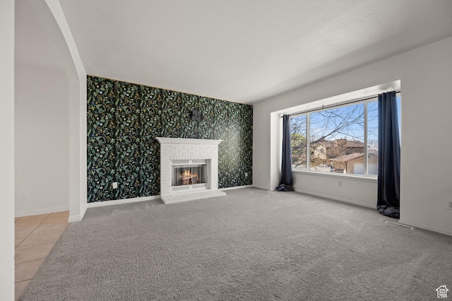 1705 E 2800 N, Layton, UT 84040 - unfurnished living room with visible vents, baseboards, an accent wall, a brick fireplace, and wallpapered walls