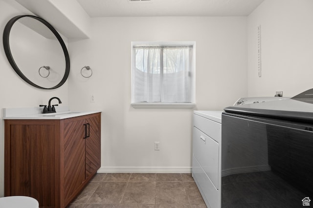 1705 E 2800 N, Layton, UT 84040 - laundry area featuring baseboards, washer and dryer, a sink, laundry area, and light tile patterned flooring