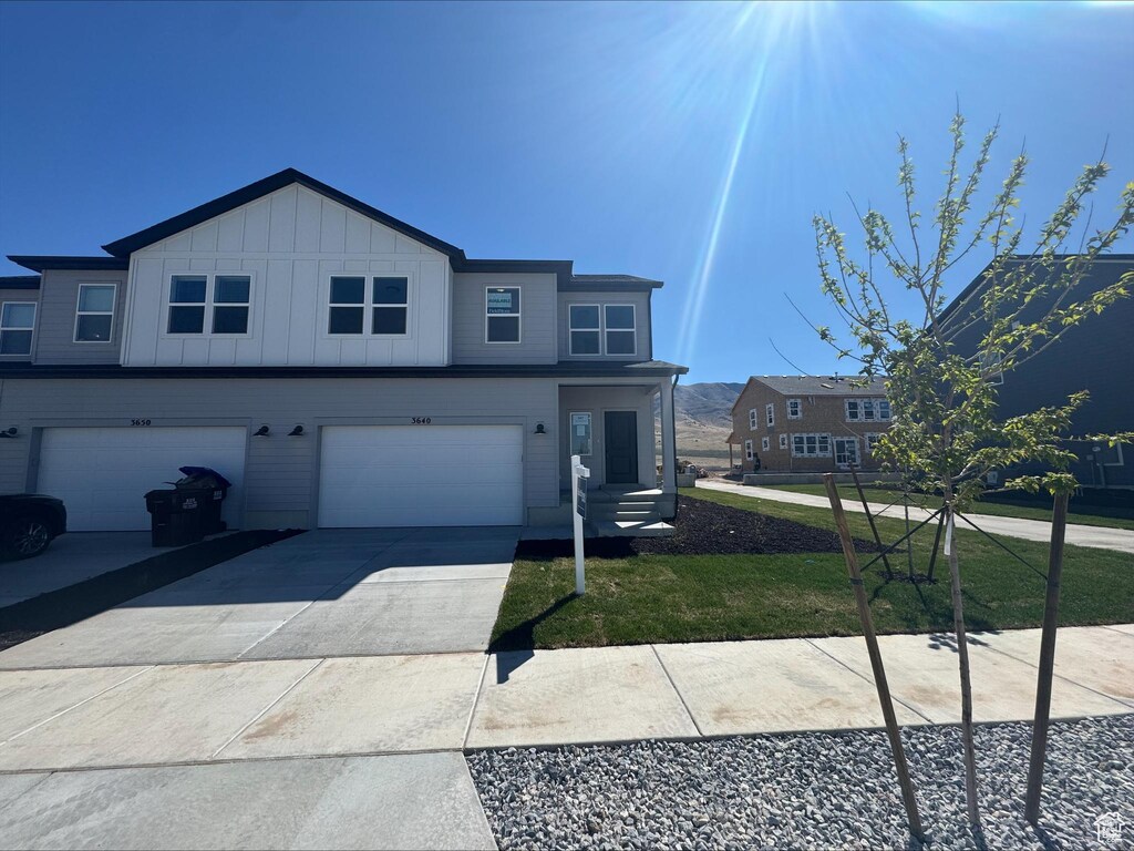 3640 N Stallion St Unit 347, Eagle Mountain, UT 84005 - view of front of property featuring an attached garage, driveway, board and batten siding, and a front yard