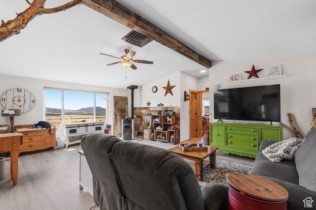 706 E Cottontail Rd, Central, UT 84722 - living room featuring visible vents, lofted ceiling with beams, a wood stove, light wood-type flooring, and a ceiling fan