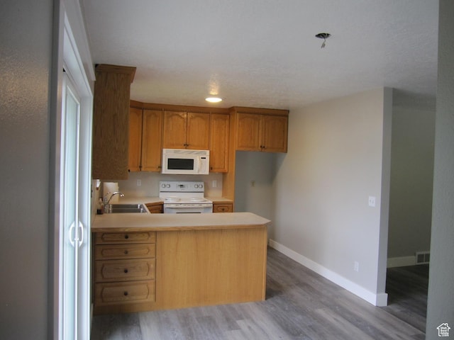 45 River Circle Dr, Logan, UT 84321 - kitchen featuring white appliances, visible vents, wood finished floors, light countertops, and a sink