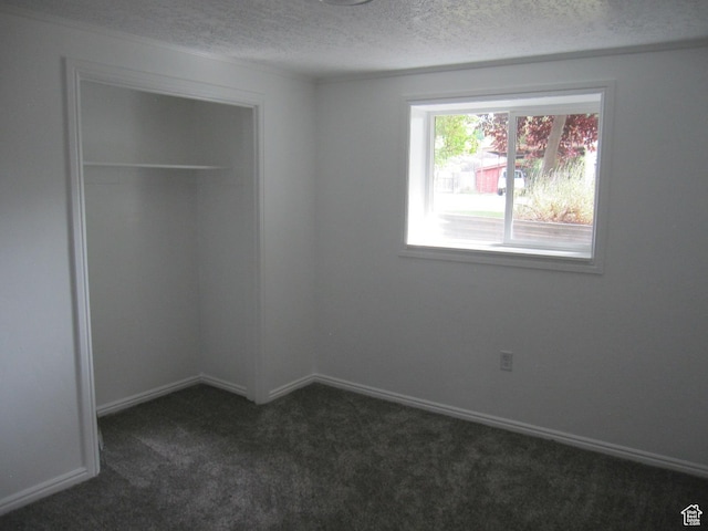 45 River Circle Dr, Logan, UT 84321 - unfurnished bedroom with a closet, dark colored carpet, a textured ceiling, and baseboards