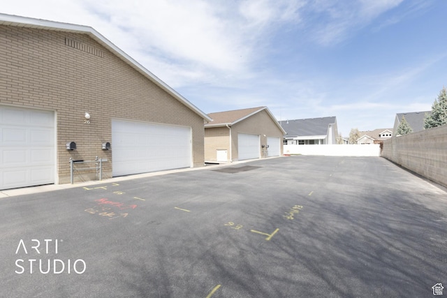 1454 W Cornerstone Dr, South Jordan, UT 84095 - view of home's exterior featuring brick siding, fence, an outdoor structure, and community garages