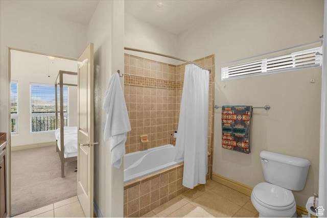 ensuite bathroom featuring baseboards, toilet, connected bathroom, tiled shower / bath combo, and tile patterned floors