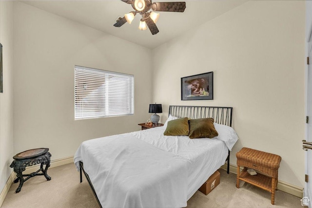 bedroom featuring ceiling fan, light colored carpet, and baseboards