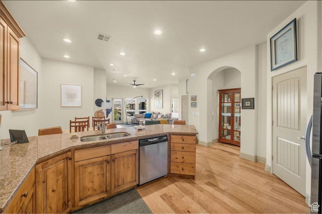 kitchen featuring light wood-type flooring, visible vents, appliances with stainless steel finishes, arched walkways, and a sink