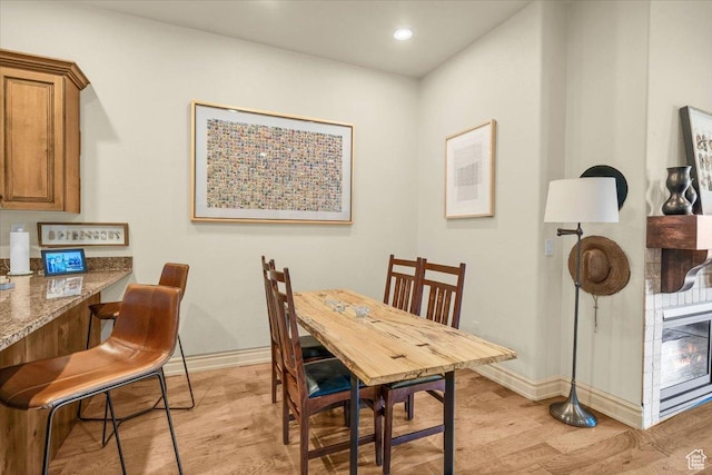 dining room with recessed lighting, light wood finished floors, and baseboards